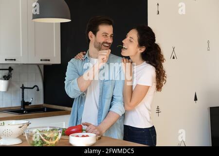 Smiling loving family couple cooking healthy meal in kitchen. Stock Photo