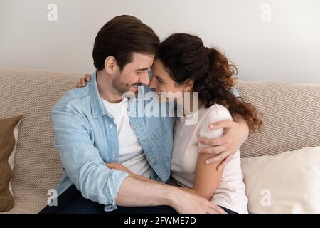 Affectionate happy caring young married couple cuddling. Stock Photo