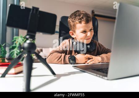 Disgruntled boy watching online video lessons on laptop Stock Photo