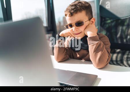 Schoolboy watches online video lessons on laptop. Studying during an epidemic Stock Photo