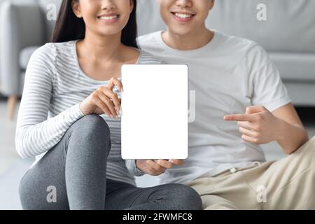 Closeup of asian couple holding digital tablet with blank screen Stock Photo