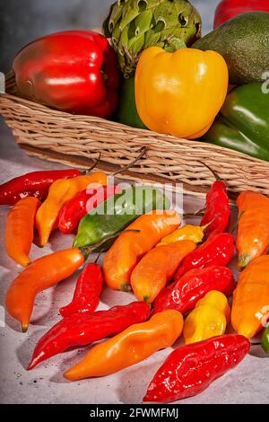 Festival of flavors and colors among chili peppers, artichokes, avocados and bell peppers Stock Photo