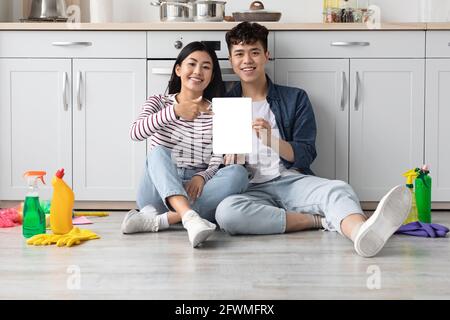 Cheerful asian couple showing digital tablet with empty screen Stock Photo
