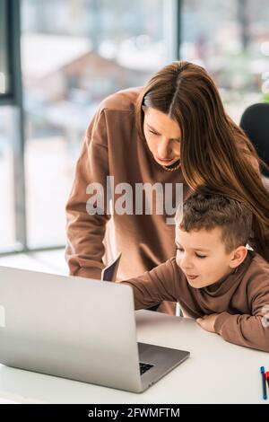 Cute mom and son doing homework at the laptop Stock Photo