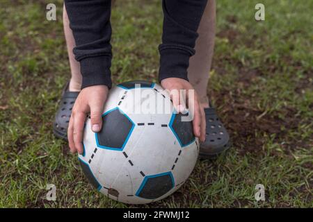 Close up view of child's hands on football. Sweden. Stock Photo