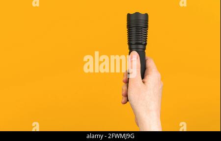 Woman hand holds flashlight on colorful isolated background photo Stock Photo