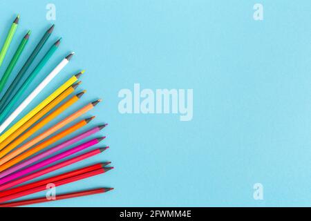 Multicolored pencils on a blue background, copy space. Stock Photo