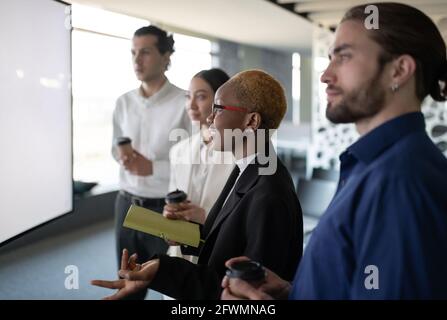 Black woman speaking during video conference with colleagues Stock Photo
