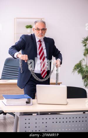 Old male employee holding chain at workplace Stock Photo - Alamy