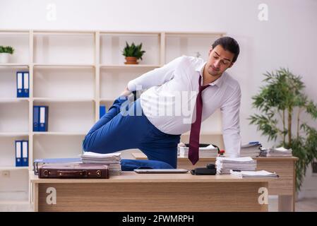 Young businessman employee doing sport exercises during break Stock Photo