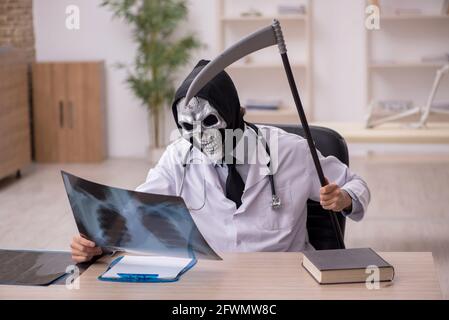 Devil doctor radiologist examining skeleton patient at the hospital Stock Photo