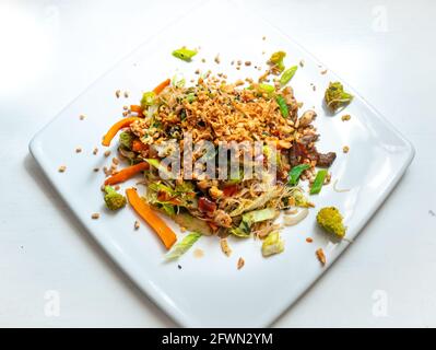 Pad Thai Vegan, Rice Noodle with Sautéed Vegetables, Broccoli, Carrot, White and Green Onion, Oyster Mushrooms, Chopped Peanuts Stock Photo