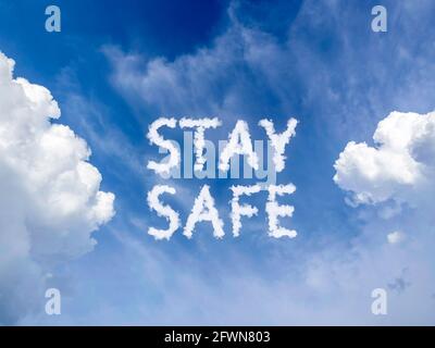 Stay safe concept. Blue sky background with white fluffy cloud message 'Stay Safe'. Poster, banner for social media campaign for covid-19 or coronavir Stock Photo