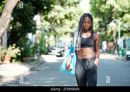 Attractive fit young woman walking to gym to have badminton training Stock Photo
