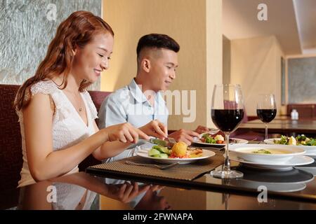 Happy young couple enjoying tasty dinner in fancy restaurant Stock Photo