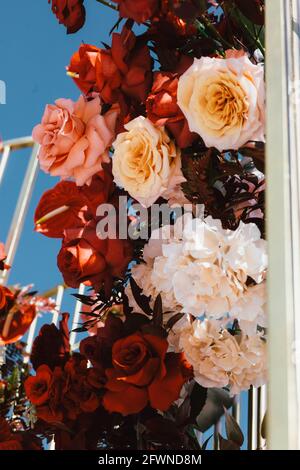 luxurious wedding arch on the river bank decorated with fresh flowers, wedding background, wedding, beautiful sunny summer day Stock Photo