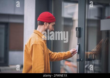 Bearded young man opening the door with an access card