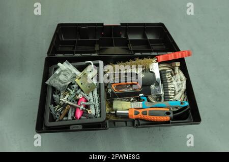Open large black box for construction tools. Carrying case with many tools on gray background Stock Photo