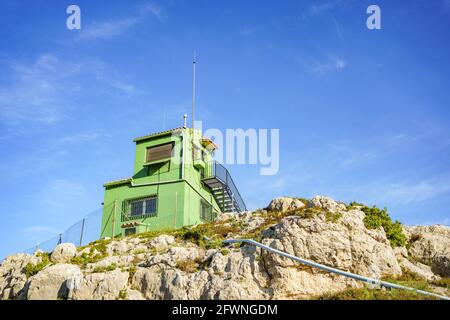 Fire surveillance tower on top of a mountain against blue sky Stock Photo