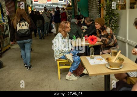 Brixton, London- May 2021: Inside Brixton Village which is part of Brixton Market- an indoor hall of world food stalls, bars and shops. Stock Photo