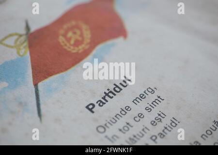 Marghia, Romania - May 5, 2021: Shallow depth of field (selective focus) details with a Romanian Communist Party flag and nationalistic poem in an old Stock Photo