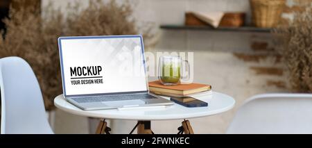Cropped shot of portable workspace with laptop, smartphone, notebook and matcha latte Stock Photo