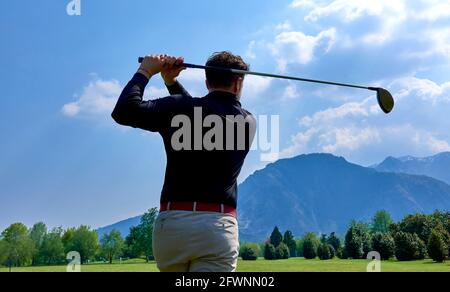 Golfer on the professional golf course. Golfer with golf club hitting the ball for the perfect shot. Stock Photo