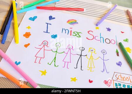 Child holding I miss School message on paper. Sadness in homeschooling during covid-19 pandemic concept. Stock Photo