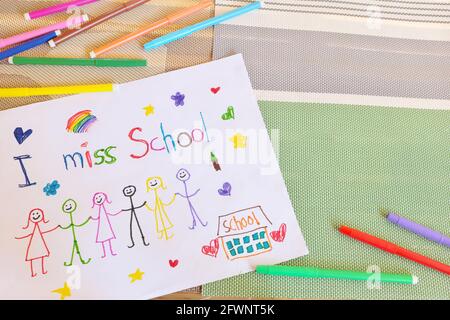 Child holding I miss School message on paper. Sadness in homeschooling during covid-19 pandemic concept. Stock Photo