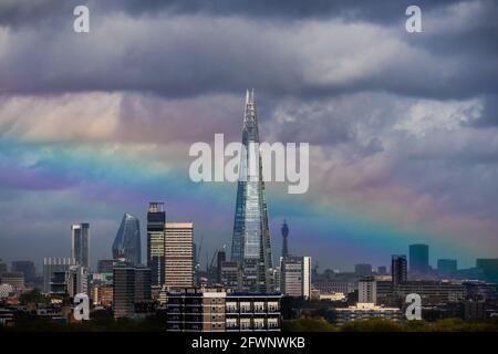 London, UK. 24th May, 2021. UK Weather: A massive rainbow breaks over The Shard skyscraper building after a brief morning rainstorm. Credit: Guy Corbishley/Alamy Live News Stock Photo