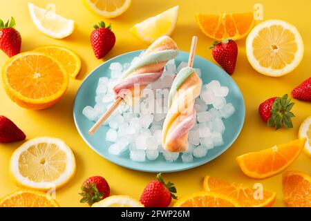Spiral colorful popsicle on yellow background Stock Photo