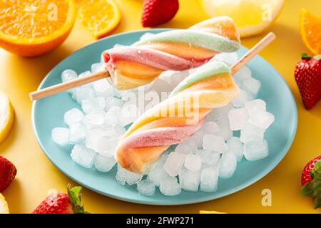 Spiral colorful popsicle on yellow background Stock Photo