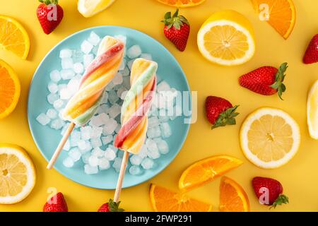 Spiral colorful popsicle on yellow background Stock Photo