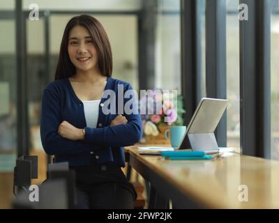 Portrait of female university student smiling to camera while sitting in cafe Stock Photo