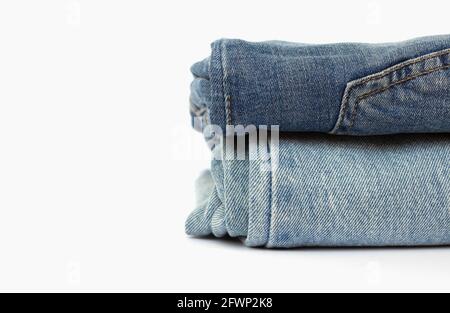 stack of blue jeans isolated on white background, space for text, close-up Stock Photo