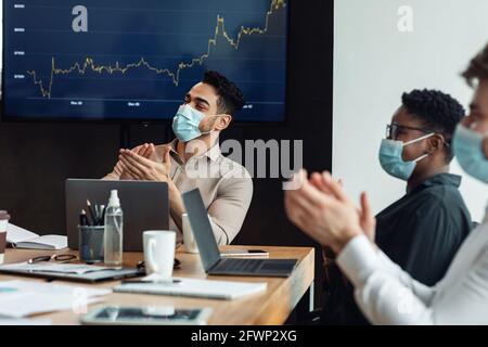 Colleagues having meeting in boardroom, clapping hands Stock Photo