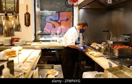 Palma, Spain. 23rd May, 2021. Andres, waiter at Bar Bosch, prepares breakfast in Palma de Mallorca. Gastronomes on the Spanish holiday island are allowed to serve guests indoors for the first time since March on 23.05.2021. Credit: Clara Margais/dpa/Alamy Live News Stock Photo