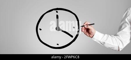 Businessman draws a clock icon on gray background. Business or project time management concept. Stock Photo