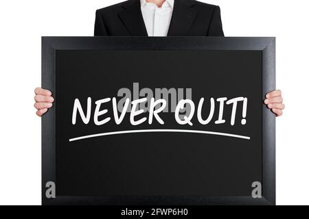 Businessman holds a big signboard with never quit message on isolated white background. Persistence and motivation in business. Stock Photo
