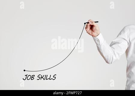 Businessman hand draws a rising line with the word job skills. Increasing business job skills with training or experience concept. Stock Photo