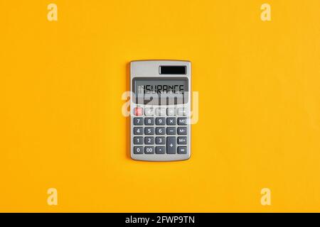 The word insurance on calculator display with yellow background. Calculating insurance costs or insurance return concept. Stock Photo