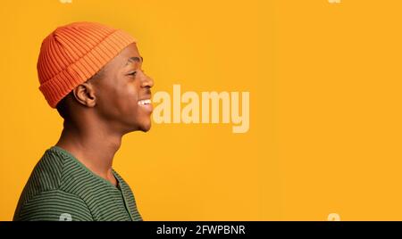Profile Portrait Of Cheerful Black Hipster Guy In Orange Hat Stock Photo