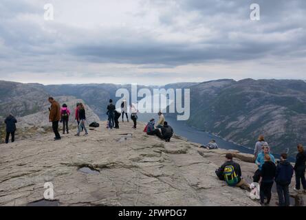 Rogaland, Norway - 23rd May, 2017: Hikers enjoying the beautiful views of the Lysefjord on an overcast day from the Pulpit rock, Norway. Also called P Stock Photo