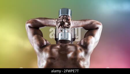 Composition of rear view of muscular strong african american man lifting dumbbells Stock Photo