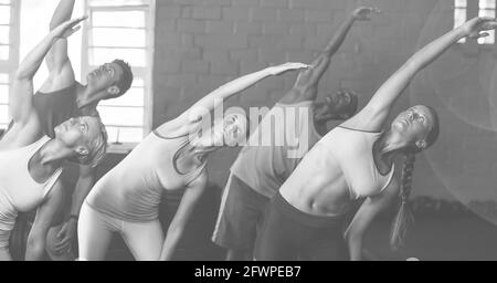 Composition of group of men women stretching exercising in fitness class in black and white Stock Photo