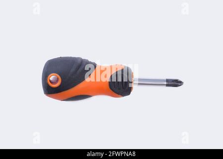 Screwdriver with black and orange rubber handle. Stock Photo