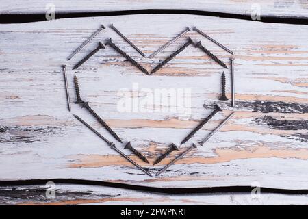 Shape of heart made from screws and nails. Stock Photo