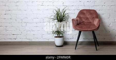 pink chair and flower pot on white brick wall background. minimalism interior design. banner copy space Stock Photo