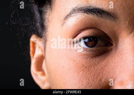 Close up of eye of african american businesswoman against grey background Stock Photo