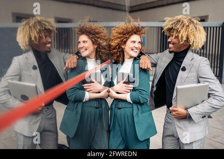 Cool afro man wearing formal clothes posing with his female colleague in the street and having fun. Stock Photo